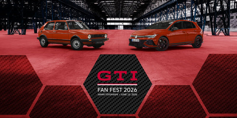 Promotional banner for GTI Fan Fest 2026 featuring two red cars in a large indoor exhibition space with a hexagon graphic foreground.