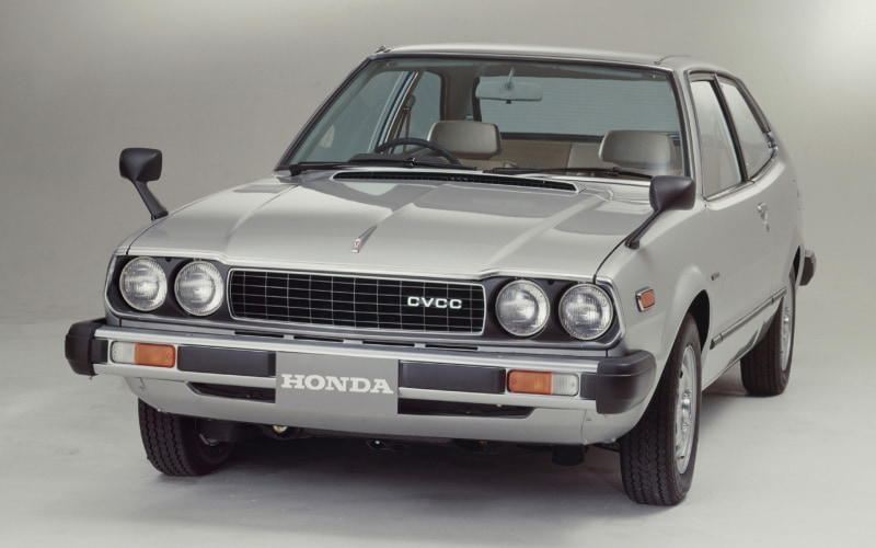 Front view of a silver vintage Honda CVCC sedan with four round headlights and a visible HONDA badge on the grille