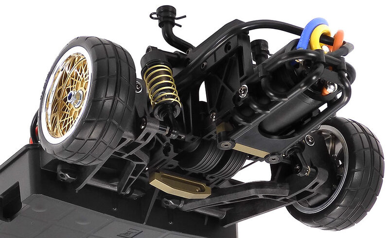 An assembled RC car chassis with exposed suspension, drivetrain, and large tread tires.