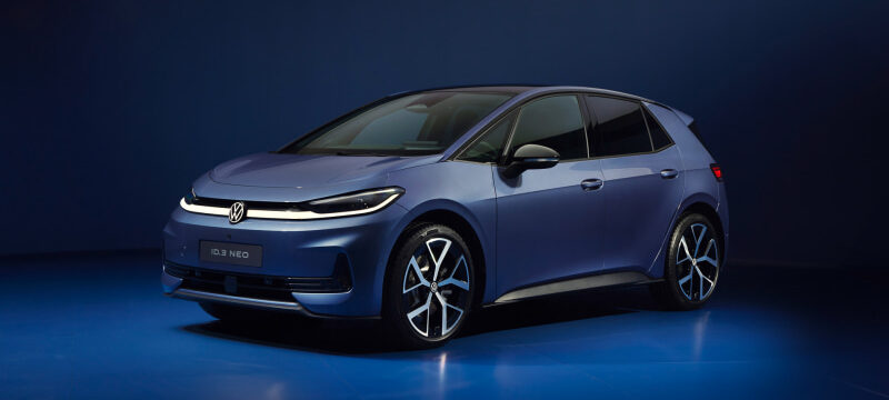 Front three-quarter view of a metallic blue Volkswagen ID.3 Neo electric hatchback on a glossy blue studio floor.