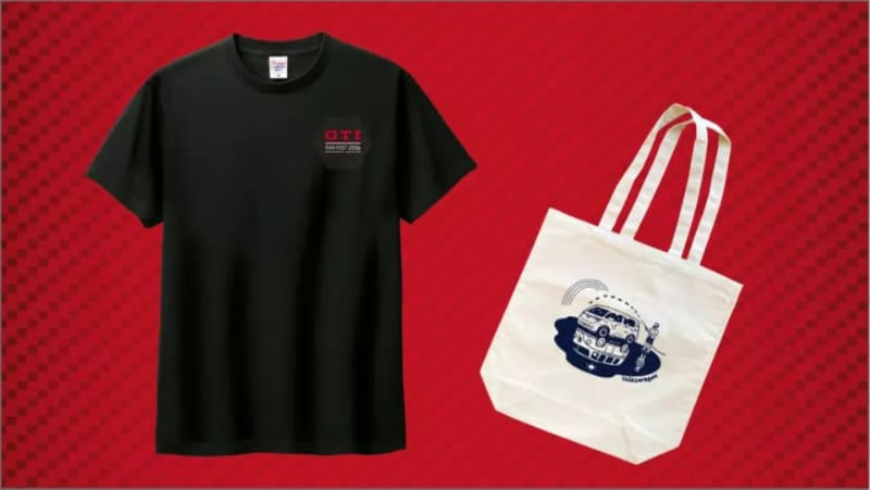 Flat lay of a black T-shirt with a small red chest logo next to a white tote bag with a blue circular car graphic on a red dotted background.