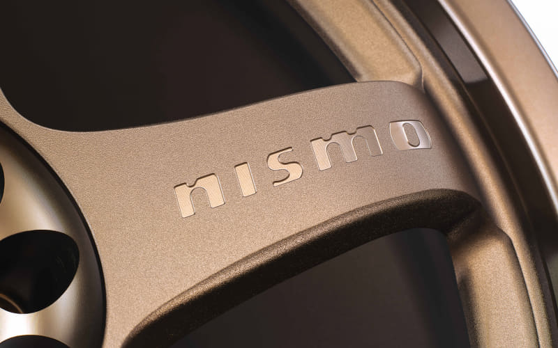 Close-up of a silver car wheel rim with the word 'mismo' embossed on the spoke.