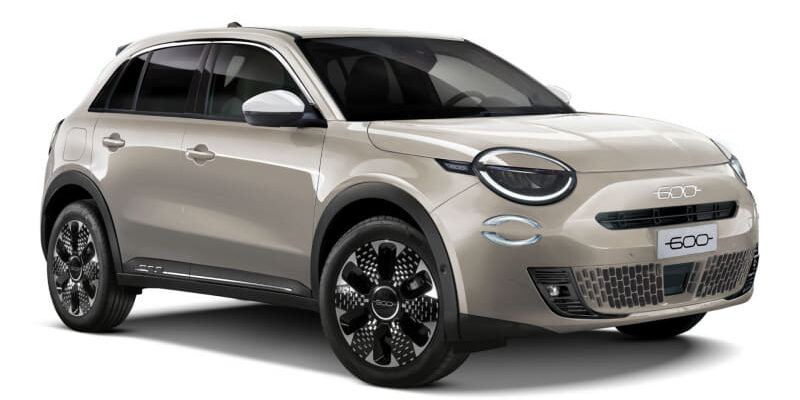 Beige compact crossover SUV photographed from the front-left, showing rounded headlights, a mesh grille, and large black alloy wheels.