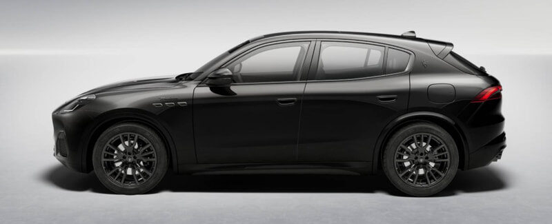 Side profile of a glossy black luxury SUV with a curved roofline and large alloy wheels in a studio setting.