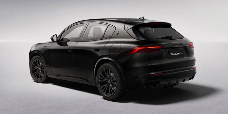 Black Maserati Grecale SUV shown from a rear-side angle on a light gray studio background, highlighting its taillights and sleek silhouette.
