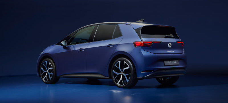 Blue Volkswagen ID.3 Neo hatchback shown from a rear three-quarter view in a studio setting, with a dark blue backdrop.
