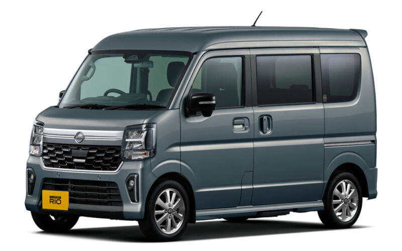Blue-gray compact van seen from the front-left, showing the sliding side door and large windows.