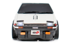 Rear view of a white sports car model with a black rear window, orange bumper reflectors, and a small license plate with the letter D