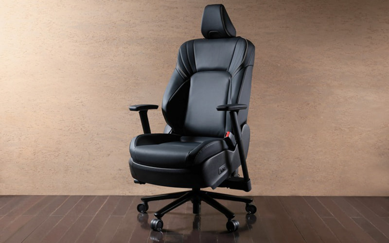 Black leather ergonomic office chair with headrest and wheels on a wooden floor.