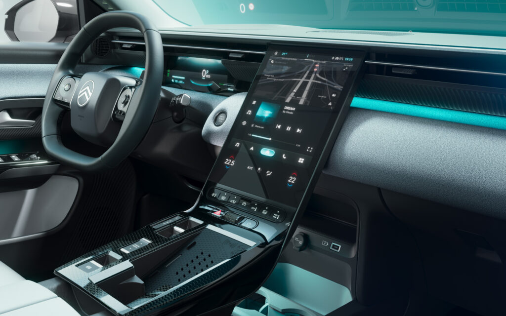 Interior of a modern car with a large vertical touchscreen center display and teal ambient lighting.