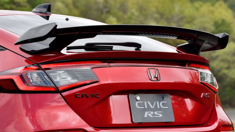 Rear view of a red Honda Civic RS with a large black spoiler and brand badges visible