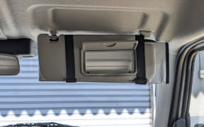 Open sunglasses holder built into the car's ceiling above the windshield (overhead console).