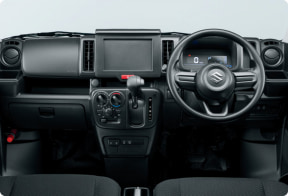 Interior of a right-hand-drive car: steering wheel on the right, central dashboard with touchscreen, climate controls, and gear shifter.