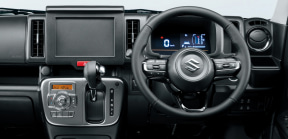 Car cockpit with digital instrument cluster, steering wheel, and center console controls.