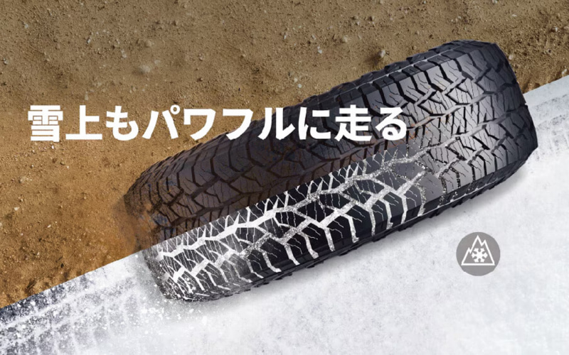Winter tire rolling over a snowy surface with a dirt area nearby, featuring the Japanese slogan '雪上もパワフルに走る'.