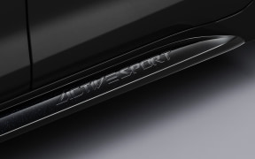 Close-up of a car's door sill/threshold with embossed branding along the running board.