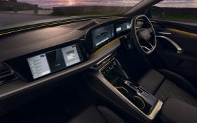 Interior of a modern right-hand-drive car with multiple digital instrument screens and a center console.