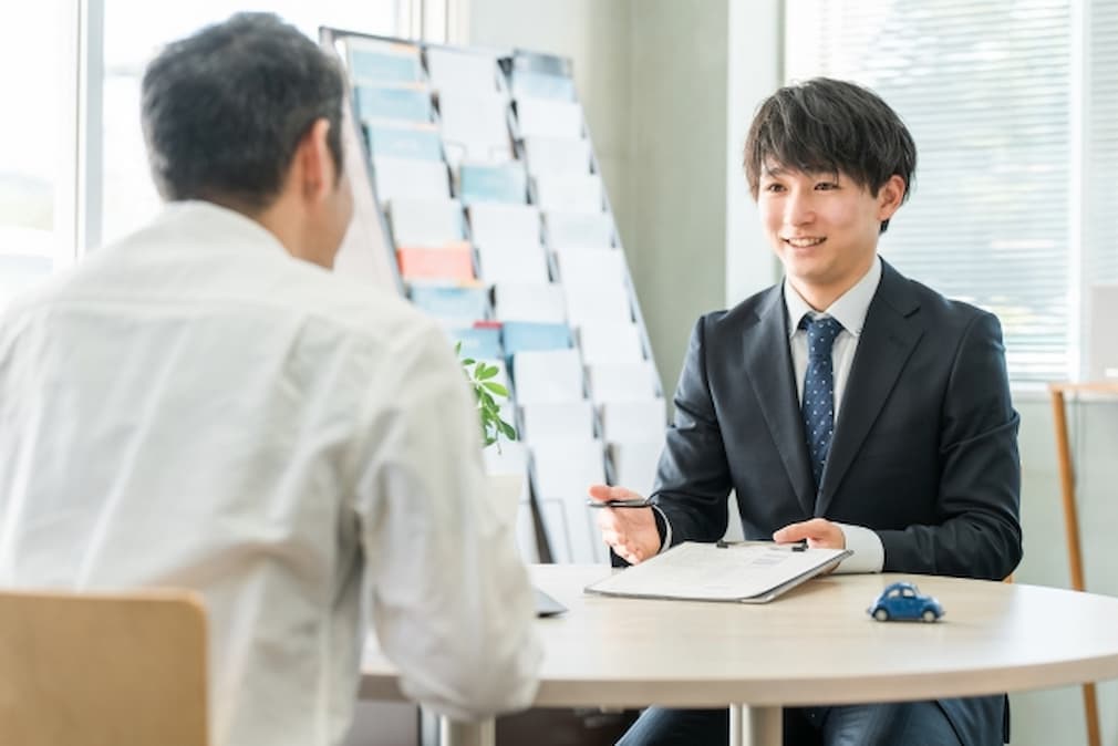 商談する男性スタッフと客