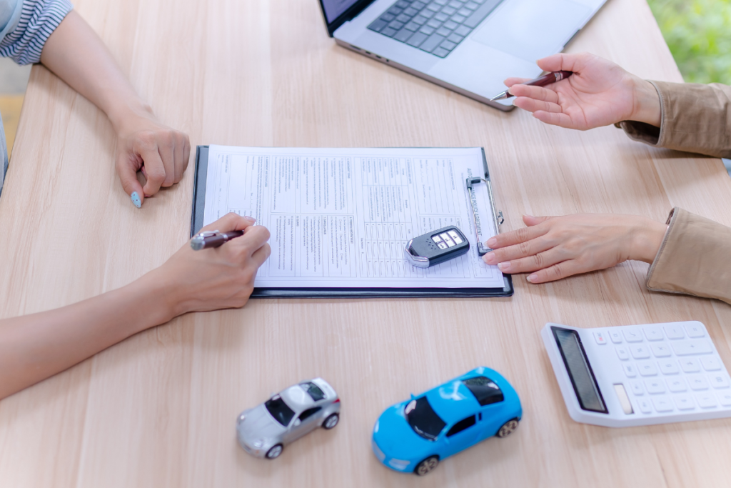 車の購入を検討している人が販売店でスタッフに相談している
