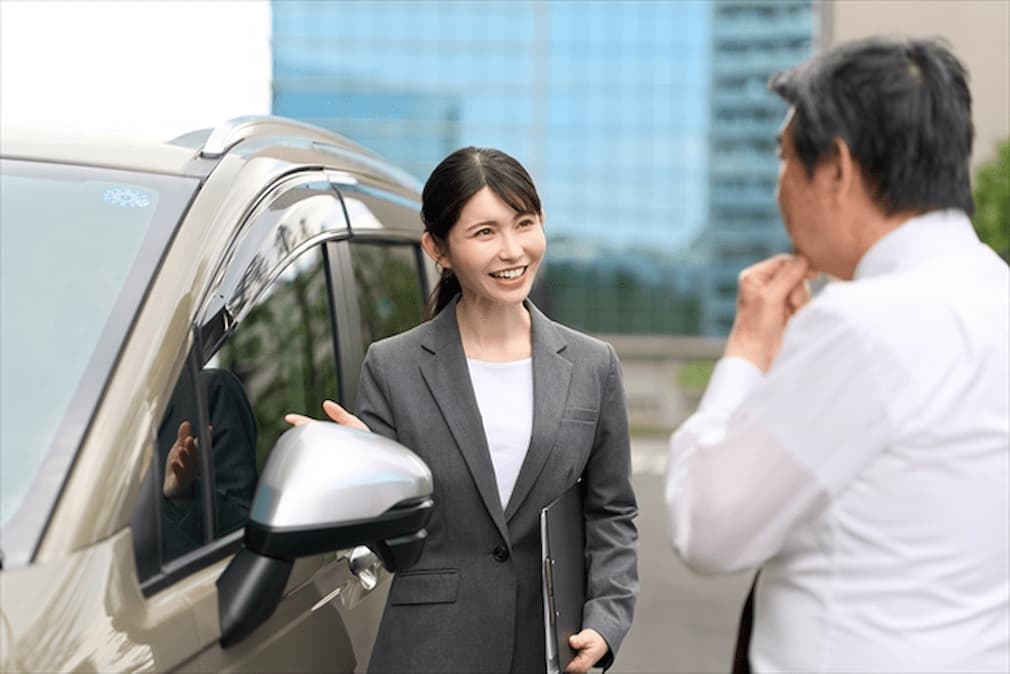 説明をする車販売店のスタッフ