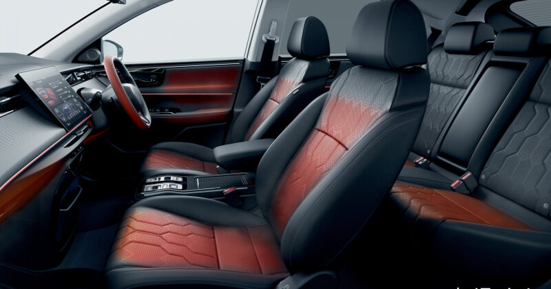 Front and back seats of a modern car interior with red and black leather upholstery.