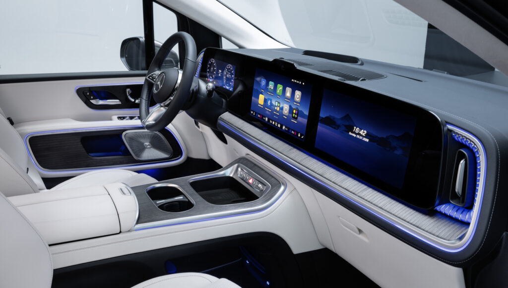 Luxurious car interior with a wide digital dashboard and center touchscreen, light-gray materials and blue ambient lighting.