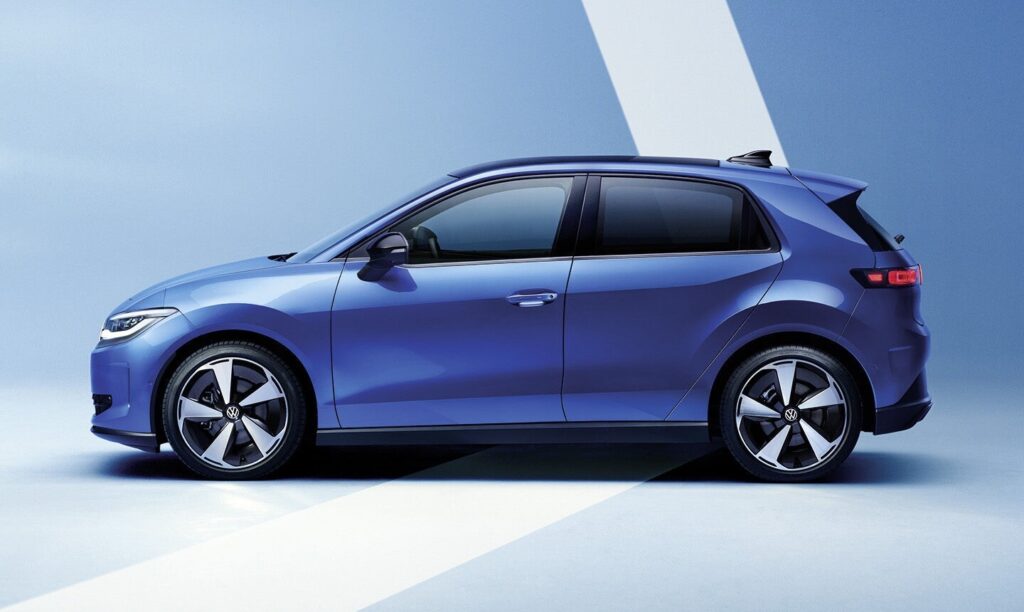 Side view of a blue hatchback car in a studio setting with large alloy wheels.