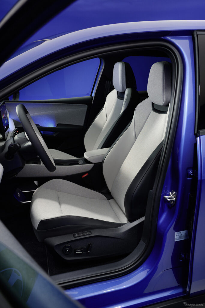 Open blue car door exposes the light-gray front seats and steering wheel inside the cabin