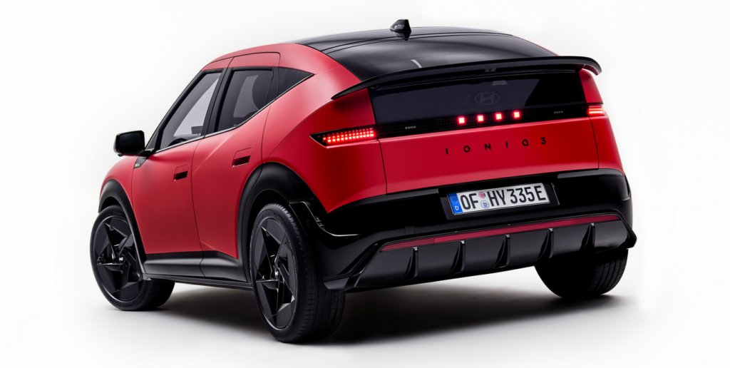 Red and black Hyundai IONIQ 3 electric SUV shown from a rear three-quarter angle against a white studio backdrop, with illuminated taillights visible.