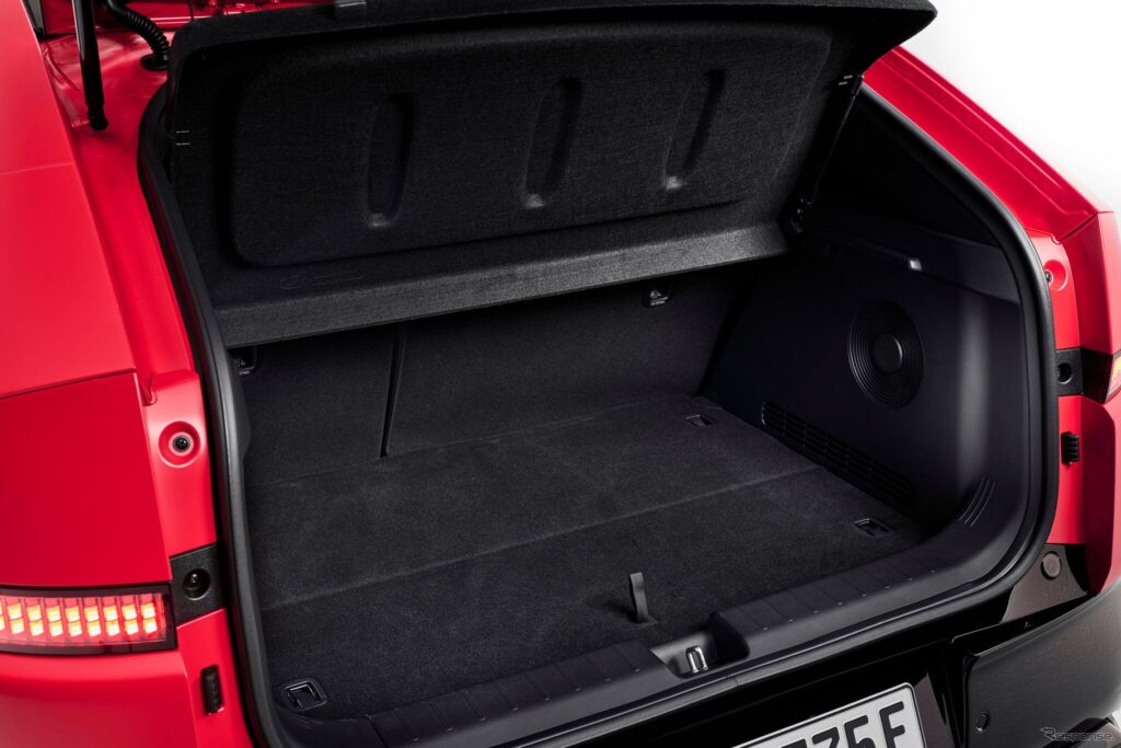 Open trunk of a red SUV showing a black cargo floor and a raised tonneau cover making the storage area visible.