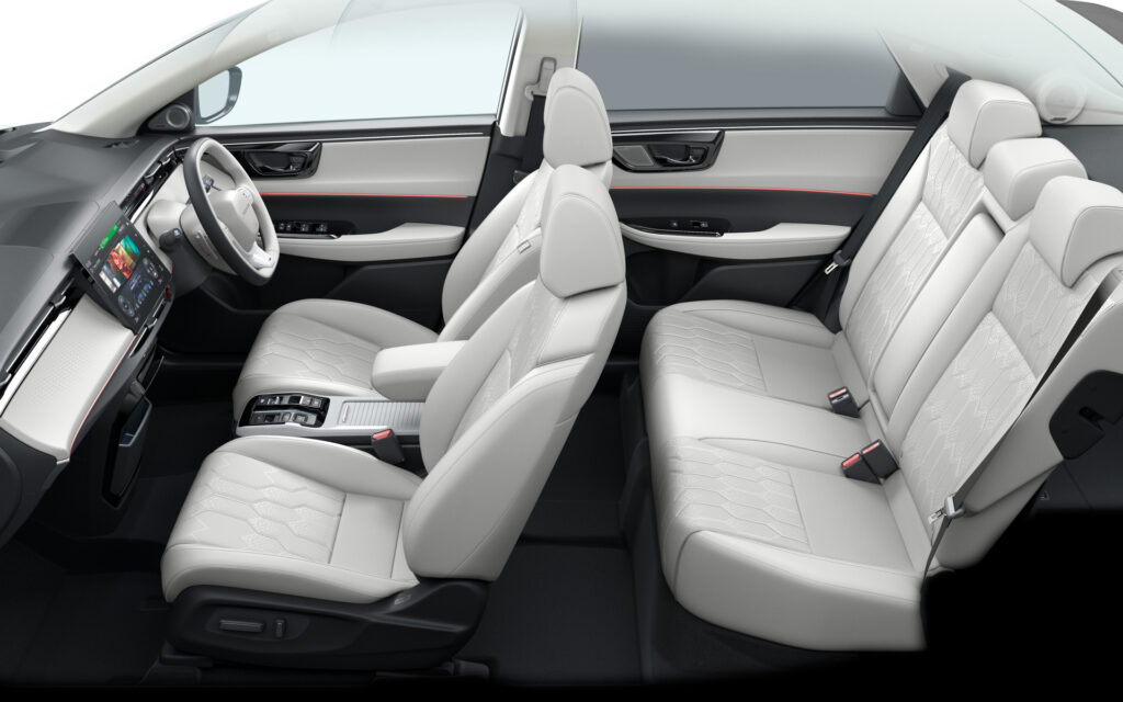 Interior of a modern car showing light gray leather seats, front and rear, with a center console and touchscreen dashboard